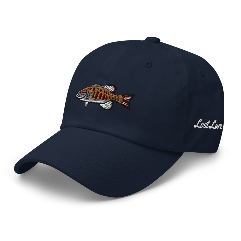 A smallmouth bass fishing hat / dad hat with a simple embroidery design of a smallie. Blue hat, front left side