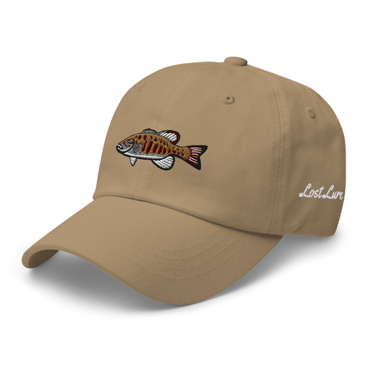 A smallmouth bass fishing hat / dad hat with a simple embroidery design of a smallie. Brown hat front left side.